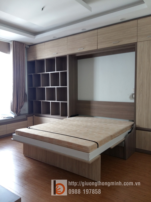 Anh đã quyết đinh sử dụng thiết kế của Wallbed, bao gồm: - 1 giường thông minh 1,6mx2m có thể gập gọn lên cùng hệ thống tủ khi không sử dụng - Sofa thông minh với khoang chứa đồ sử dụng tiếp khách và ngồi xem ti vi thư giãn - Hệ thông tủ quần quần áo bên cạnh và phía trên cung cấp không gian lưu trữ quần áo gọn gàng - Hệ thống giá sách, băng kệ dọc cửa sổ và bàn học tạo lên khu vực làm việc và đọc sách trang nhã - Kệ tủ ti vi thiết kế tinh tế